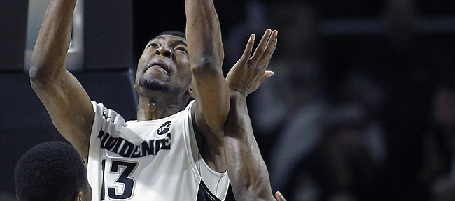 Providence center Paschal Chukwu (13) goes up for a shot against Marquette guard Derrick Wilson during the first half of a game, Sunday, March 1, 2015, in Providence, Rhode Island.