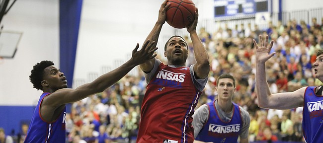 Red Team guard Frank Mason takes the ball to the hoop against Blue Team players Lagerald Vick, left, and Sviatoslav Mykhailiuk during a scrimmage, Wednesday, June 10, 2015 at the Horejsi Family Athletic Center.