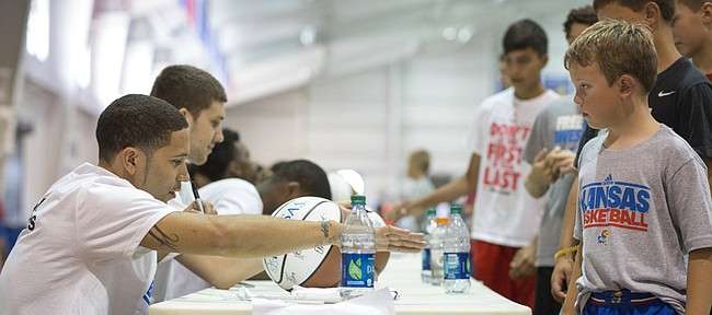 SMU's Nic Moore signs autographs for fans during the registration for Bill Self's basketball camp Sunday at Anschutz Sports Pavilion.