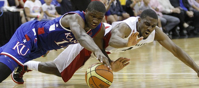 Kansas forward Carlton Bragg, left, hits the floor for a loose ball with Canada guard Jarred Ogungbemi-Jackson in the first-half of a Team USA exhibition game against Canada Tuesday, June 23, at the Sprint Center in K.C., MO.
