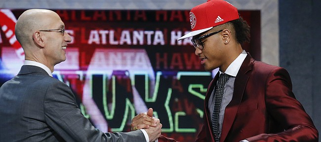 Kelly Oubre Jr., right, is greeted by NBA Commissioner Adam Silver after being selected 15th overall by the Atlanta Hawks during the NBA basketball draft, Thursday, June 25, 2015, in New York. (AP Photo/Kathy Willens)
