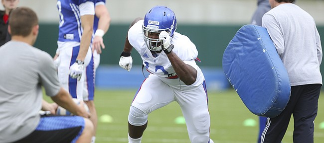 Kansas defensive end Damani Mosby comes off a block as he and other members of the special teams unit work on punt blocking during practice on Monday, April 7, 2015.