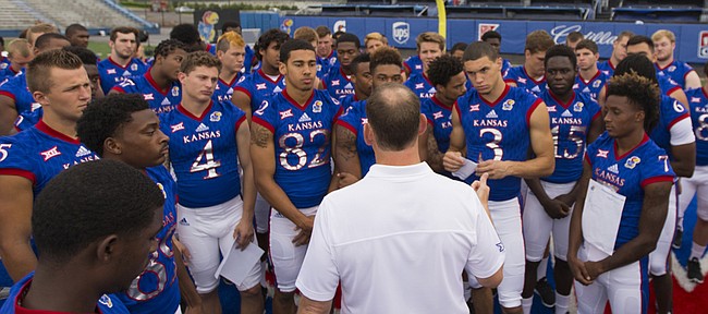 Head coach David Beaty talks with his team prior to a round of portraits with media members on Saturday, Aug. 8, 2015 at Memorial Stadium.