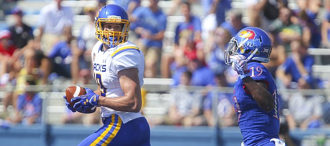 South Dakota State wide receiver Jake Wieneke (19) turns back to see Kansas cornerback Tyrone Miller Jr. (19) trailing as he runs into the end zone for a touchdown during the first quarter on Saturday, Sept. 5, 2015 at Memorial Stadium.