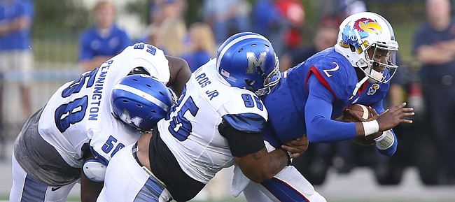 Kansas quarterback Montell Cozart (2) is dragged down in the backfield by Memphis defensive lineman Donald Pennington (58) and defensive lineman Michael Edwards (95) during the second quarter on Saturday, Sept. 12, 2015 at Memorial Stadium.