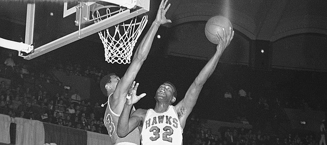 Wilt Chamberlain of the Philadelphia 76ers reaches to block the shot of Bill Bridges (32) of the St. Louis Hawks in National Basketball Assn., game in St. Louis, on Sunday, afternoon, Jan. 29, 1967.
