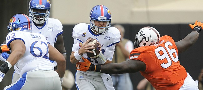 Kansas quarterback Ryan Willis (13) is wrapped up for a sack by Oklahoma State defensive tackle Vincent Taylor (96) during the first quarter on Saturday, Oct. 24, 2015 at T. Boone Pickens Stadium in Stillwater, Okla.