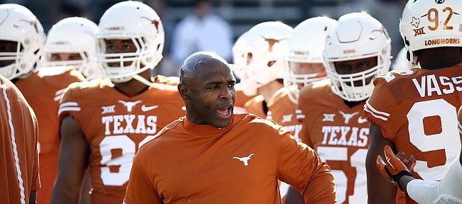 In this Oct. 10, 2015, Texas head coach Charlie Strong talks with his team during warm-ups before an NCAA college football game against Oklahoma in Dallas.