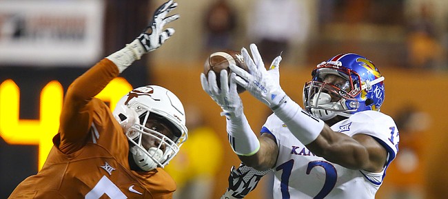 Kansas wide receiver Darious Crawley (12) eyes the ball as Texas defensive back Holton Hill (5) swoops in to bat it away during the third quarter on Saturday, Nov. 7, 2015 at Darrell K. Royal Stadium in Austin, Texas.