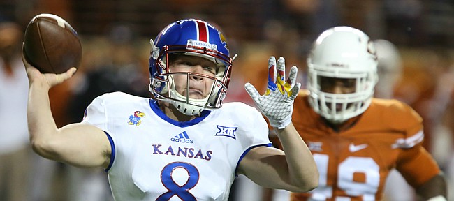 Kansas backup quarterback Keaton Perry (8) pulls back to throws as Texas safety Kevin Vaccaro (18) closes in during the fourth quarter on Saturday, Nov. 7, 2015 at Darrell K. Royal Stadium in Austin, Texas.
