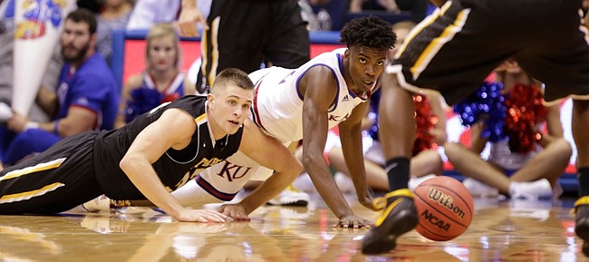 Kansas guard Lagerald Vick (2) and Fort Hays State forward Dom Samac (24) slides across the floor while competing for a loose ball during the first half, Tuesday, Nov. 10, 2015 at Allen Fieldhouse.