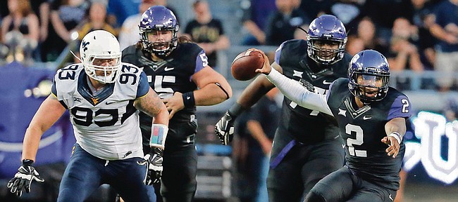 TCU quarterback Trevone Boykin (2) scrambles out of the pocket under pressure from West Virginia’s Kyle Rose (93) in this photo from Oct. 29 in Fort Worth, Texas. Kansas needs to find a way to limit the damage done by Boykin on Saturday.