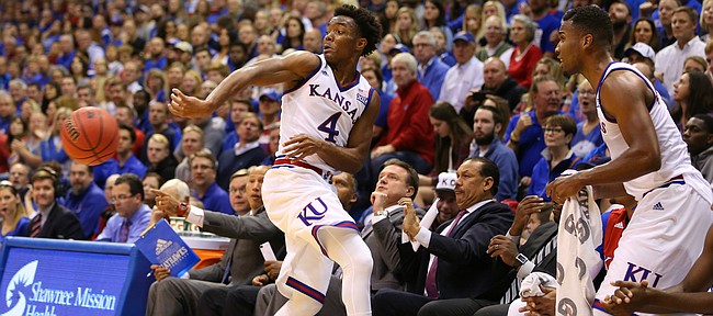 Kansas guard Devonte' Graham (4) slings a pass around his back as he collides into the Kansas bench during the second half, Friday, Nov. 13, 2015 at Allen Fieldhouse.
