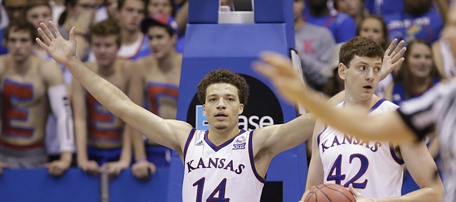 Kansas guard Brannen Greene (14) raises up his hands as he questions being called for a foul during the first half on Wednesday, Nov. 4, 2015 at Allen Fieldhouse. Also pictured are Kansas forward Hunter Mickelson (42) and Pittsburg State guard Chris Owens (5).