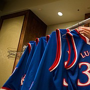 Kansas University men's basketball student managers, Chip Kueffer, Baldwin City, works behind a rack of uniforms as he works to fold and bundle jerseys, shorts and other articles of clothing for the Jayhawks prior to a team meeting on Tuesday, Nov. 24, 2015 at the Westin Maui in Lahaina, Hawaii. The managers abide by a strict procedure for organizing and laundering all of the gear that accompanies the Jayhawks during their travels but often have to improvise on the road when faced with a quick turnaround between games.