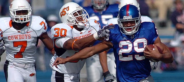 Kansas University Running back Jon Cornish (29) tries to escape from the Oklahoma State defense in a 2006 game at Memorial Stadium. Cornish announced his retirement from the Canadian Football League on Wednesday.