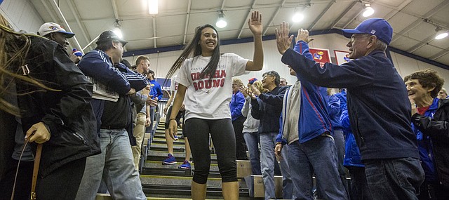 Wearing a shirt that reads "Omaha Bound" and a huge smile, Kansas University volleyball sophomore setter Ainise Havili gives out high-fives and hugs as she walks through the crowd gathered at the Horejsi Center to welcome the team back to Lawrence on Sunday. The night before in San Diego, Calif., Kansas outlasted No. 1-ranked USC in a five-set match that saw the Jayhawks come from behind to score the final six points for an upset victory and their first ever Final Four berth. The ninth-seeded Jayhawks will next face fourth-seeded Nebraska in a national semifinal match on Thursday in Omaha. The first serve is set for 8:30 p.m.