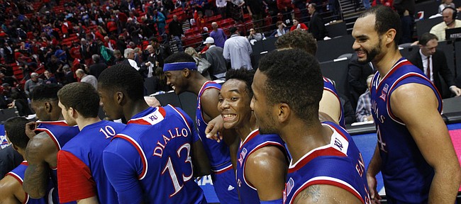 Kansas guard Devonte' Graham flashes a wide smile as he and the Jayhawks wait to slap hands with San Diego State players after their 70-57 win, Tuesday, Dec. 22, 2015 at Viejas Arena in San Diego.