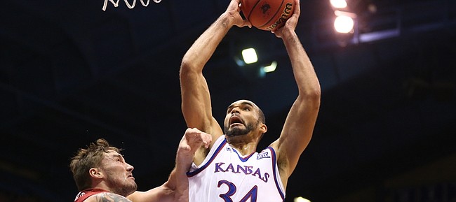 Kansas forward Perry Ellis (34) gets fouled by Oklahoma forward Ryan Spangler (00) on his way to the bucket during the second half, Monday, Jan. 4, 2016 at Allen Fieldhouse.