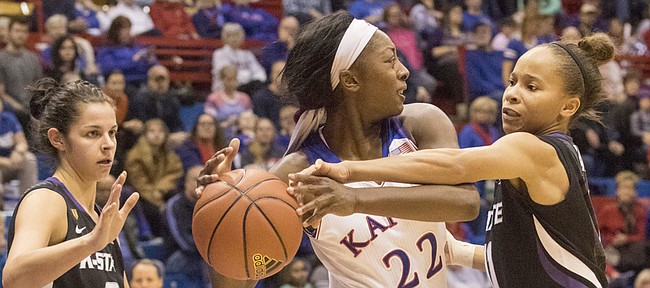 Kansas sophomore Chayla Cheadle (22) loses the ball as it is stripped away by Kansas State's Antoinette Taylor, right, while Cheadle tries to escape a double team by Taylor and Jessica Sheble (0) during the Sunflower Showdown game Wednesday evening at Allen Fieldhouse. 