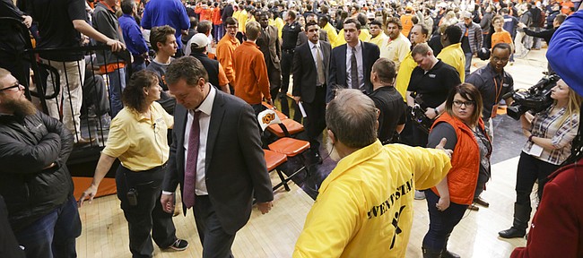 Oklahoma State security helps to shield as Kansas head coach Bill Self and his staff leave the court following the Jayhawks' 86-67 loss to Oklahoma State on Tuesday, Jan. 19, 2016 at Gallagher-Iba Arena in Stillwater, Okla.
