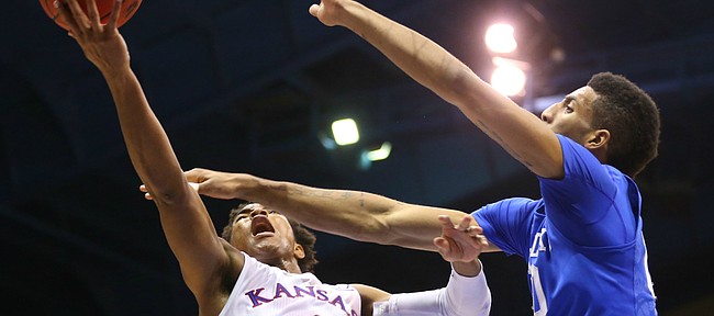 Kansas guard Devonte' Graham (4) puts a shot off the glass as he is fouled by Kentucky forward Marcus Lee (00) during the second half, Saturday, Jan. 30, 2016 at Allen Fieldhouse.