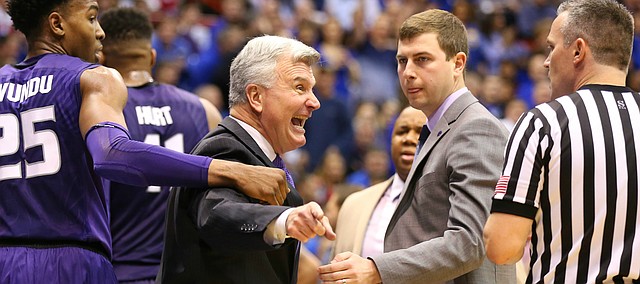 Kansas State head coach Bruce Weber is pulled back by Kansas State forward Wesley Iwundu (25) while disputing an out-of-bounds ball during the first half on Wednesday, Feb. 3, 2016 at Allen Fieldhouse.
