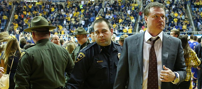 Kansas coach Bill Self is escorted off the court as West Virginia fans rush the court after defeating the Jayhawks 74-63 on Tuesday, Jan. 12, 2016, at the WVU Colliseum in Morgantown, W.Va. The rematch will be Tuesday at Allen Fieldhouse.