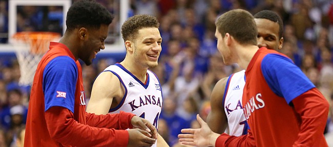 Kansas guard Brannen Greene, second from left, is congratulated by teammates after a three during the second half, Tuesday, Jan. 9, 2016 at Allen Fieldhouse.