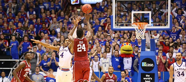 Kansas guard Devonte' Graham (4) defends against a three from Oklahoma guard Buddy Hield (24) in triple overtime, Monday, Jan. 4, 2016 at Allen Fieldhouse.