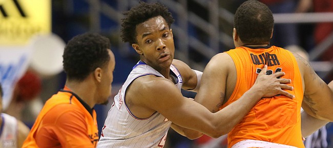 Kansas guard Devonte' Graham looks to move around Oklahoma State forward Chris Olivier (31) as he defends against Oklahoma State guard Tyree Griffin (2) during the first half, Monday, Feb. 15, 2016 at Allen Fieldhouse.