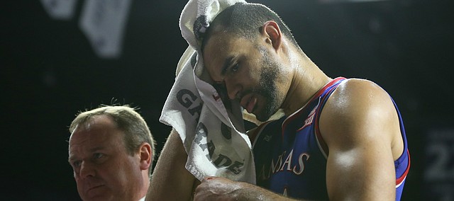 Kansas forward Perry Ellis leaves the game next to trainer Bill Cowgill after suffering a cut on his head during the second half, Saturday, Feb. 20, 2016 at Bramlage Coliseum in Manhattan, Kan.