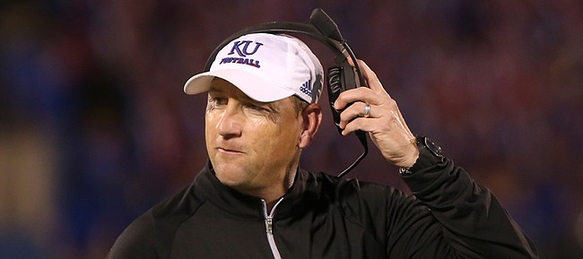 Kansas head coach David Beaty pulls off his headset after an offensive series during the fourth quarter on Saturday, Sept. 12, 2015 at Memorial Stadium.