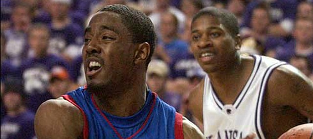 Kansas point guard Aaron Miles (11) dishes on the baseline in this Lawrence Journal-World file photo from 2005.
