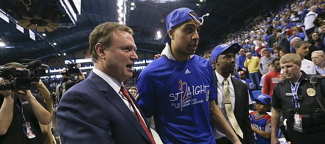Kansas head coach Bill Self walks off with forward Landen Lucas after locking up a share of their twelfth-straight Big 12 title with the trophy following their 67-58 win over the Red Raiders, Saturday, Feb. 27, 2016 at Allen Fieldhouse.