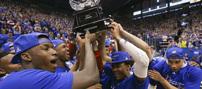 The Jayhawks celebrate locking up a share of their twelfth-straight Big 12 title with the trophy following their 67-58 win over the Red Raiders, Saturday, Feb. 27, 2016 at Allen Fieldhouse.