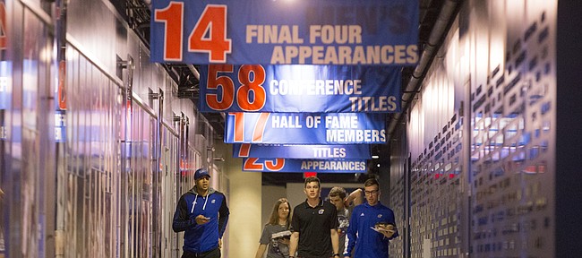 Kansas forward Landen Lucas, left, walks a long hallway toward the team locker room along side several team managers for the Jayhawks shortly before a news conference following the NCAA Tournament selection show on CBS, Sunday, March 13, 2016 at Allen Fieldhouse on the campus of the University of Kansas in Lawrence, Kan. The Jayhawks were given the No. 1 seed in the South Regional and will play Austin Peay on Thursday in Des Moines.