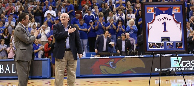 Broadcaster Bob Davis pats his heart as he receives a standing ovation from the fieldhouse before the final game of his 37-year career during a halftime ceremony on Saturday, March 5, 2016 at Allen Fieldhouse.