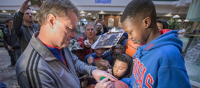Kansas head coach Bill Self signs autographs for young Jayhawk fans upon the team's arrival at the Embassy Suites Downtown Des Moines, Iowa, Tuesday, March 15, 2016.