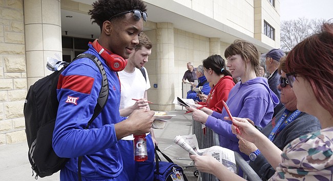 Kansas University guards Devonté Graham, front, and Tyler Self sign items for fans near the basketball facilities on KU's campus, Tuesday afternoon, March 22, 2016. The Jayhawks are heading to Louisville for the Sweet 16 of the NCAA Tournament, which begins Thursday.