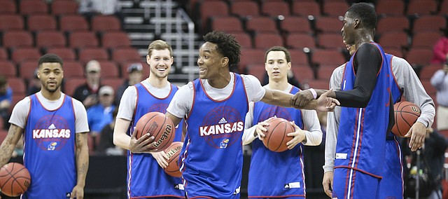 Kansas Jayhawks guard Devonte' Graham and his teammates laugh as forward Cheick Diallo tries to yank him out of line while the team shoots half court shots for dun during practice on Wednesday, March 23, 2016 at KFC Yum! Center in Louisville, Kentucky.