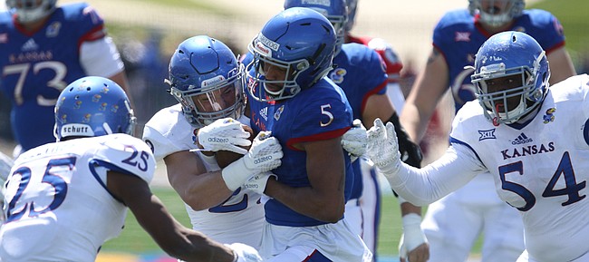 Kansas wide receiver Bobby Hartzog Jr. (5) is brought down by linebacker Joe Dineen Jr. (29) during the Spring Game on Saturday, April 9, 2016 at Memorial Stadium. At left is cornerback Marnez Ogletree (25) and at right is defensive tackle Jacky Dezir (54).