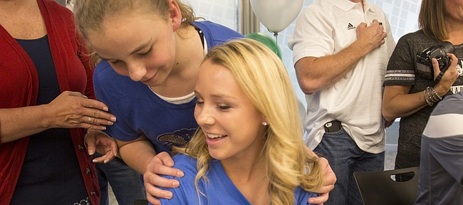 Free State senior Callie Hicks, front, gets a hug from her sister, Carly Hicks, 12, on Wednesday, May 4, 2016, at Free State as Callie signed with Kansas University. 
