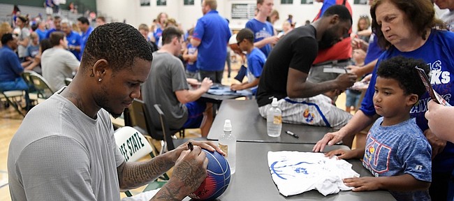 Former Kansas Jayhawk and current Sacramento King Ben McLemore signs a ball after the Rock Chalk Roundball Classic on Thursday at Free State High.