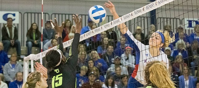 Kansas junior Tayler Soucie spikes the ball past Baylor's Katie Staiger, left, Tola Itiola (15) and Shelly Fanning (5) during their volleyball match Saturday afternoon at the Horejsi Center. 