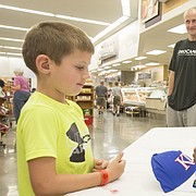 Former Kansas University star forward Perry Ellis signs an autograph for five-year-old Packson McDaniel, of Lawrence, Saturday afternoon at Hy-Vee, 3504 Clinton Parkway.