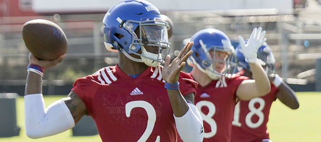Kansas junior Montell Cozart (2) works out with quarterbacks Keaton Perry (8) and Tyriek Starks (18) during practice on Thursday, Aug. 4, 2016.