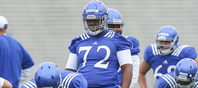 Kansas newcomer, Charles Baldwin, 72, a transfer from Alabama, gets stretched out with the offensive line during practice on Monday, Aug. 15, 2016 at Memorial Stadium.