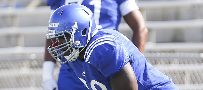 Hakeem Adeniji gets set as he works out with the rest of the offensive line during Kansas football practice on Friday, Aug. 19, 2016 at Memorial Stadium.