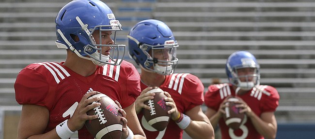 Kansas quarterbacks, from left to right, Ryan Willis, Carter Stanley and Keaton Perry warm up for KU's fan appreciation day practice on Saturday, August 20th at Memorial Stadium. 